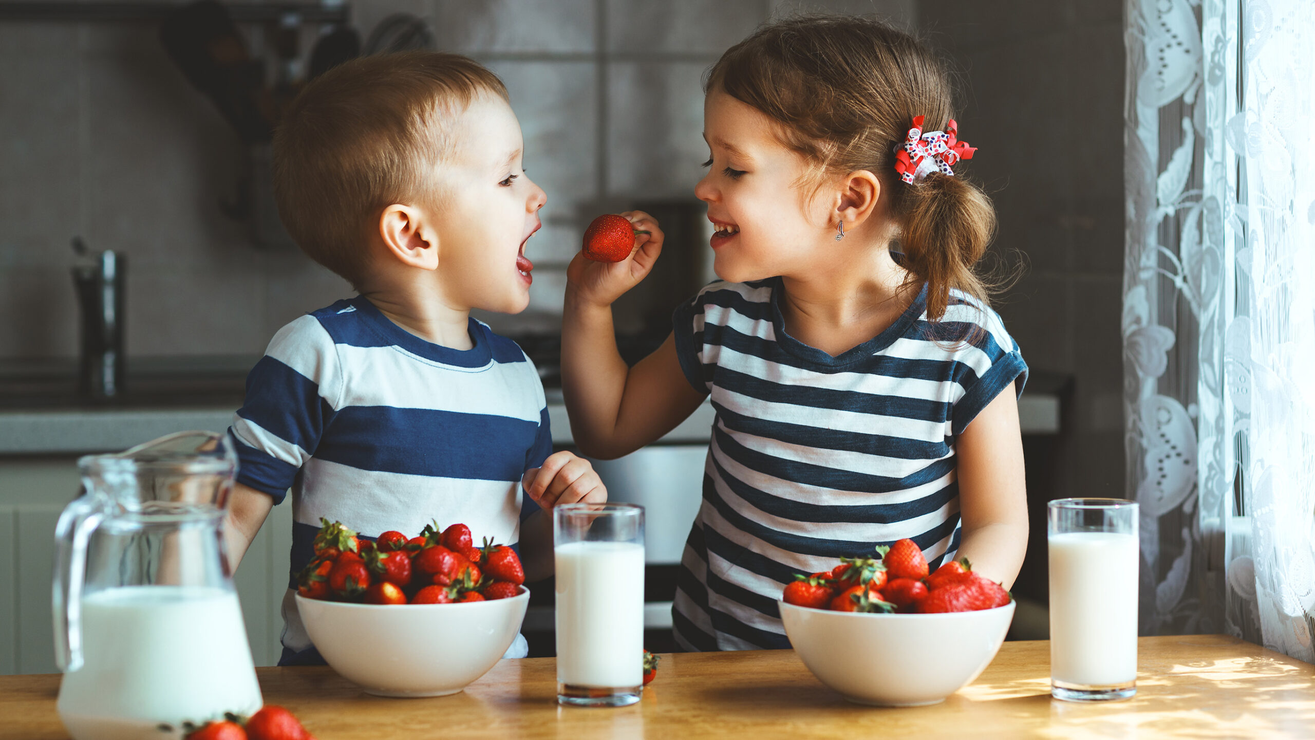 Siblings Enjoy Milk And Strawberries Together