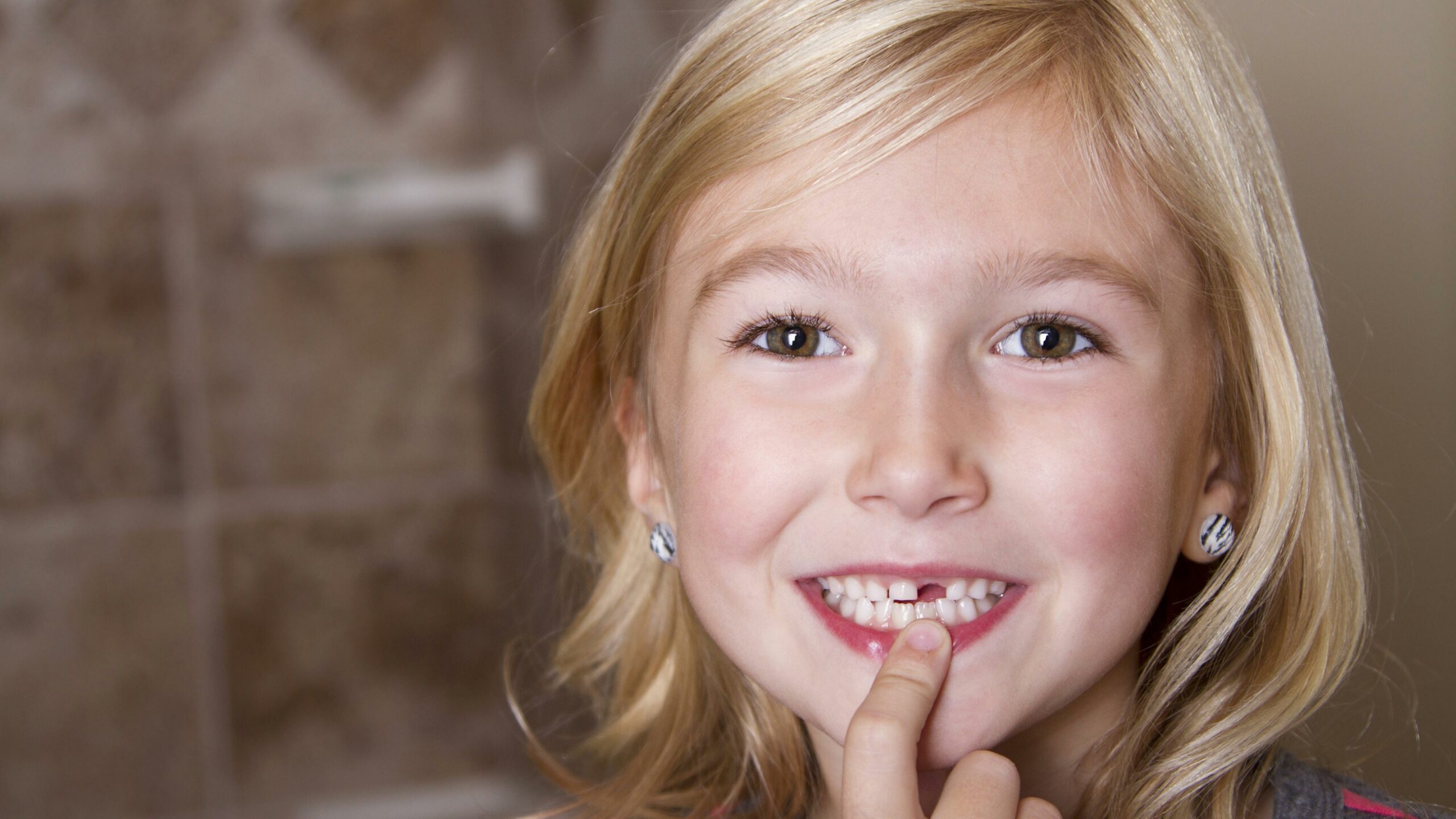 Girl Smiles And Points To Her Recently Lost Tooth