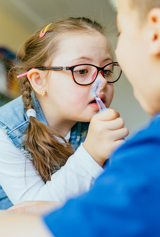 Child With Down Syndrome Learning To Brush Teeth