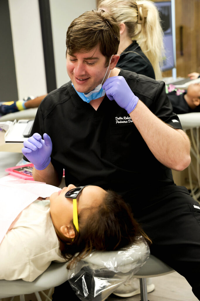 Dr. Dallin Roberts examines a child's teeth during a dental appointment