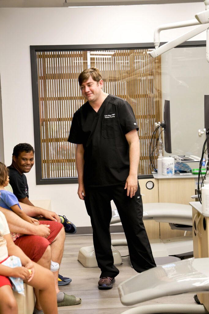 Dr. Dallin Roberts welcomes a young patient to the treatment room